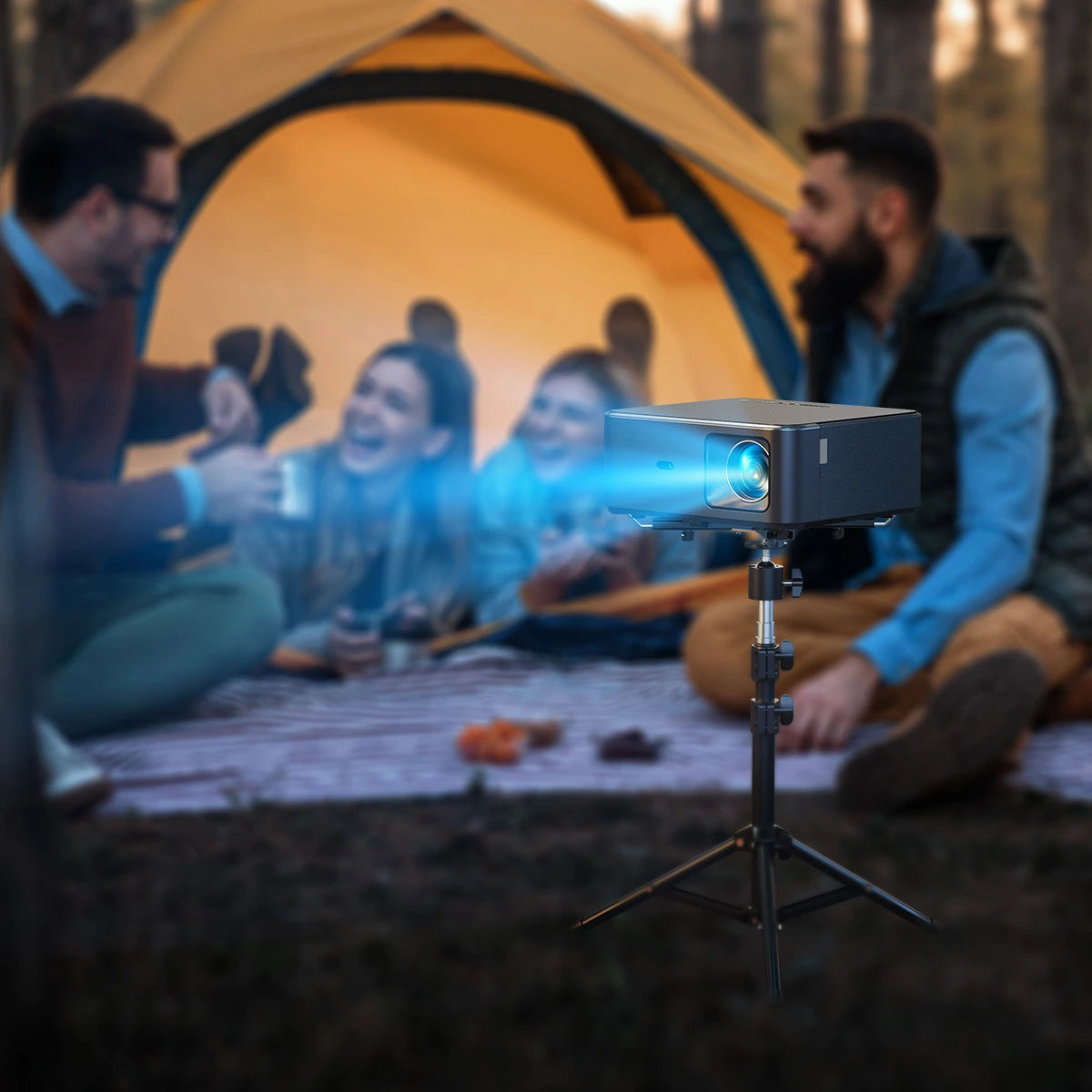 Yaber Projector on a stand with people sitting around a campfire