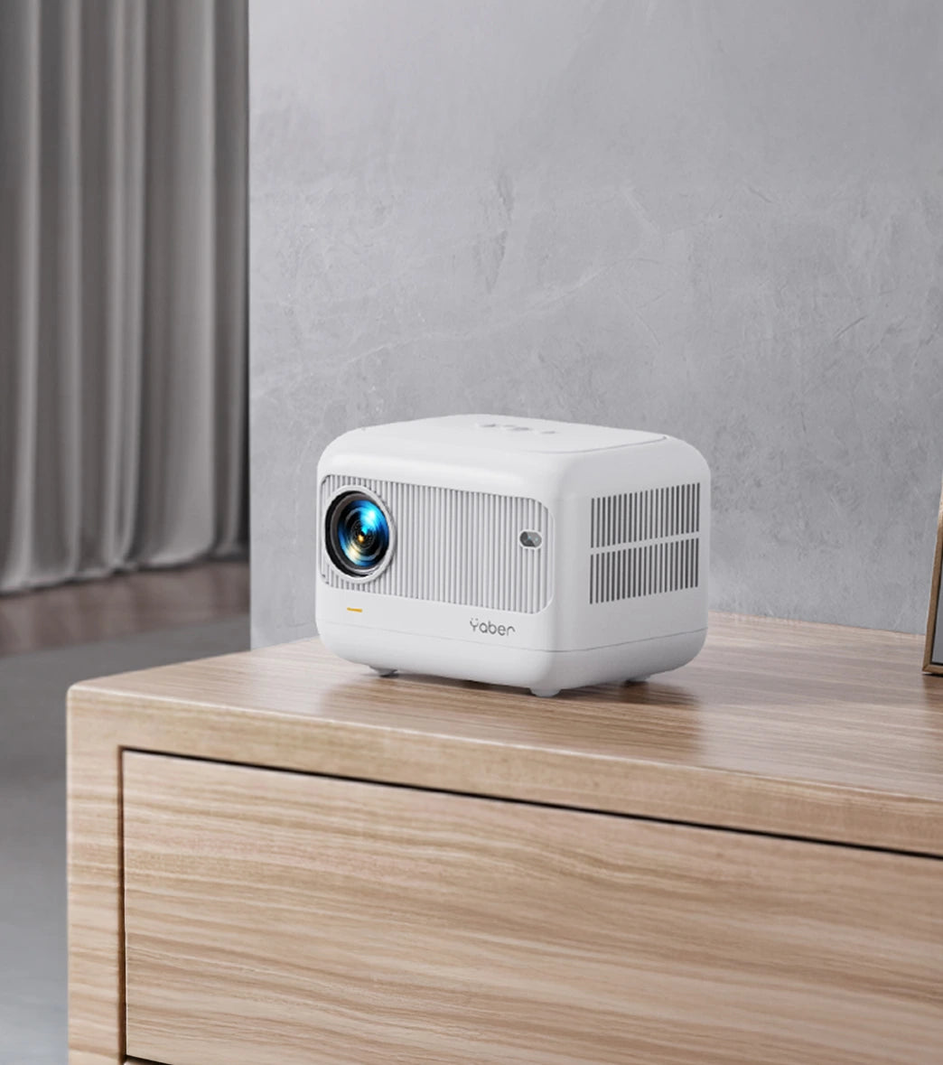 White compact yaber projector on a wooden surface with a neutral background