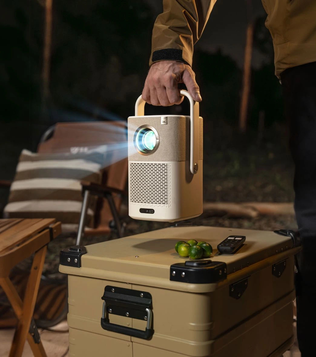 Person holding a Yaber portable T2 Plus projector over a cooler.