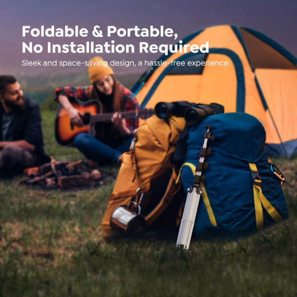 Two people camping with a tent, backpack, and guitar on a grassy field.