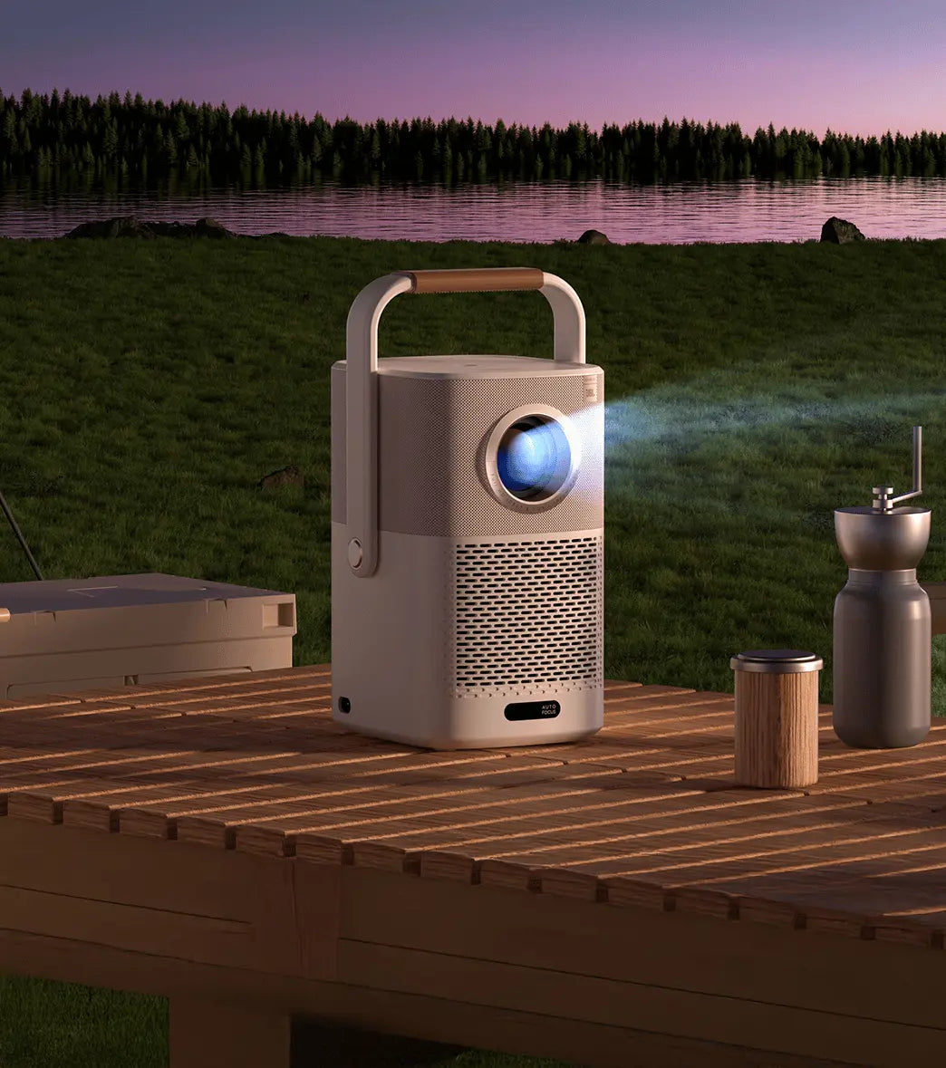 Yaber Portable projector on a wooden deck with a scenic background of water and trees.